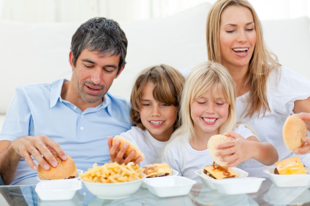 Victoria Tolstoy and Silda Wall Spitzer in a beloved family scene, eating hamburgers and fried on a sofa