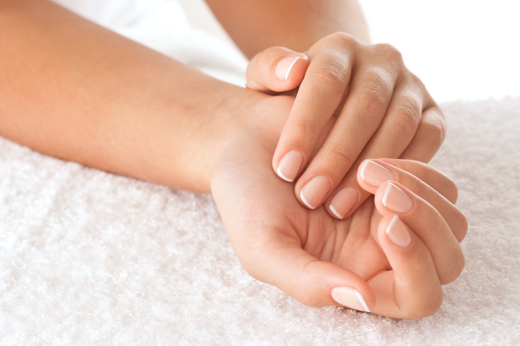 A close to the beautiful hands of a woman who rely on a white towel